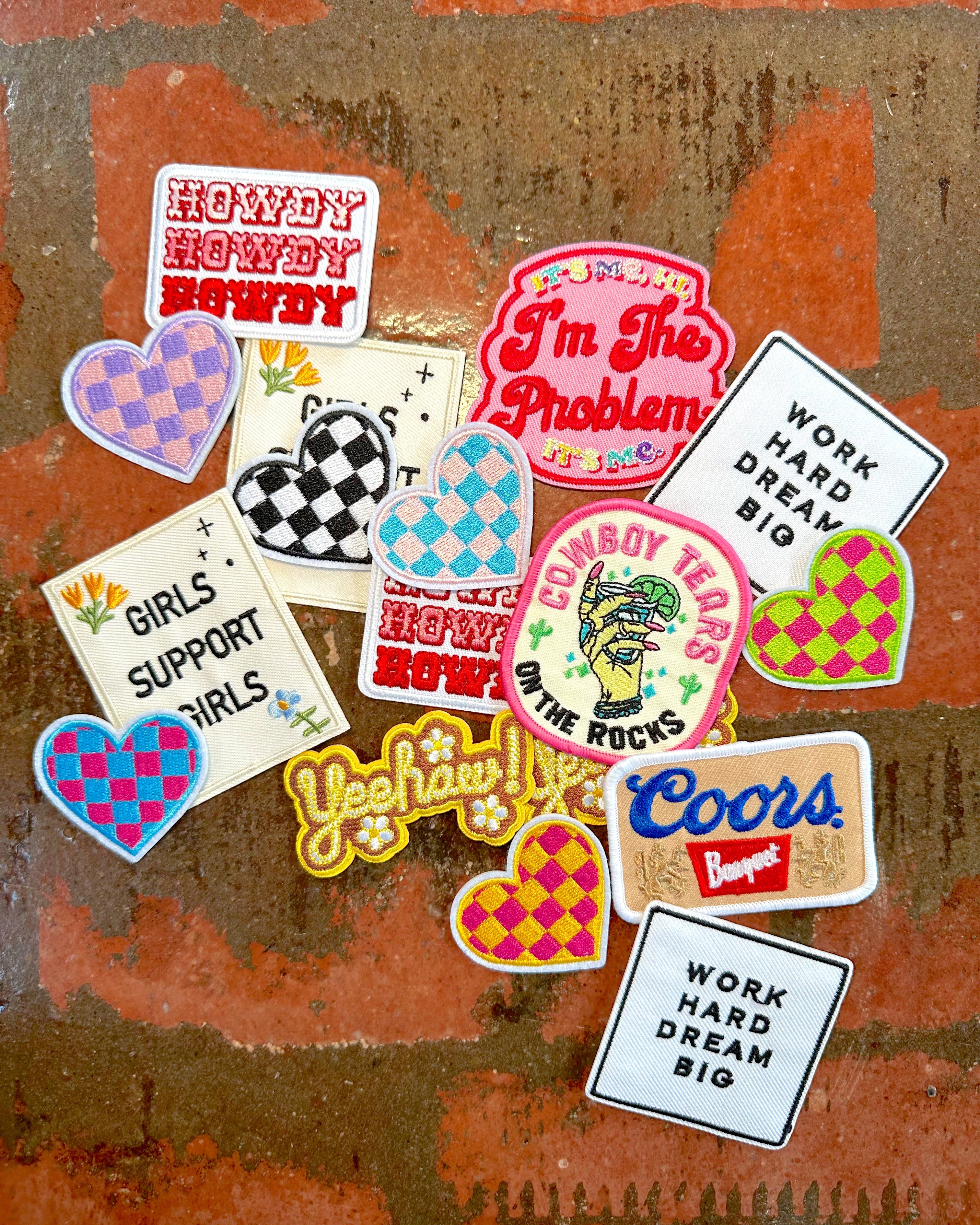 Collection of colorful embroidered patches on a textured brown background